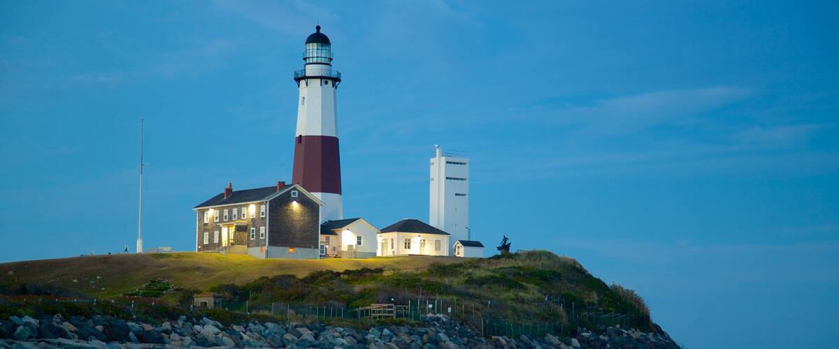 Montauk Point Lighthouse featuring rocky coastline, a lighthouse and a sandy beach
