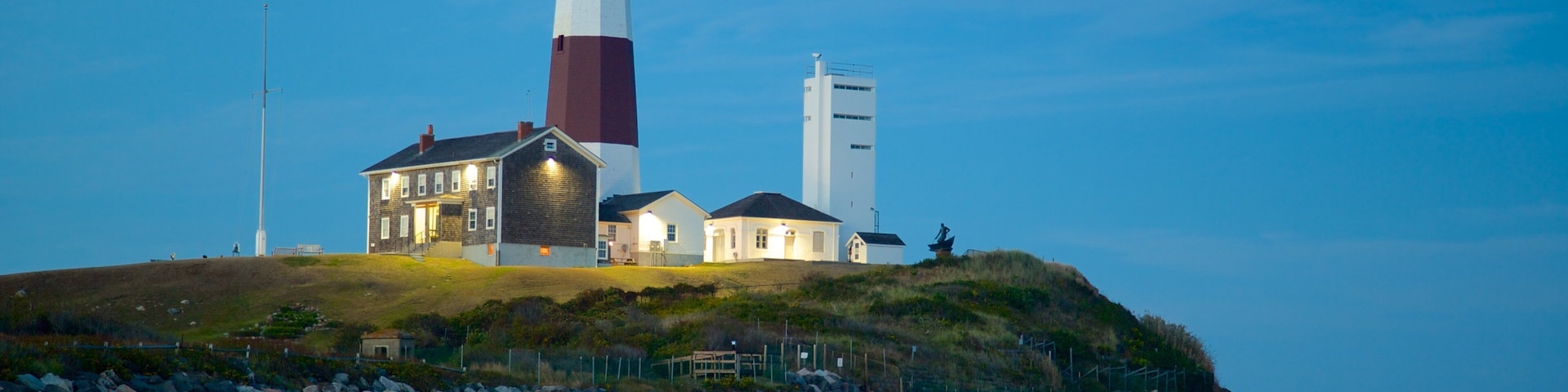 Montauk Point Lighthouse featuring rocky coastline, a lighthouse and a sandy beach