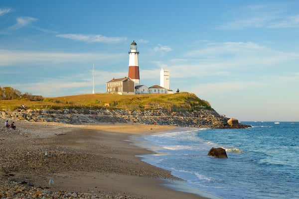 Montauk Point Lighthouse featuring rugged coastline, a beach and a lighthouse