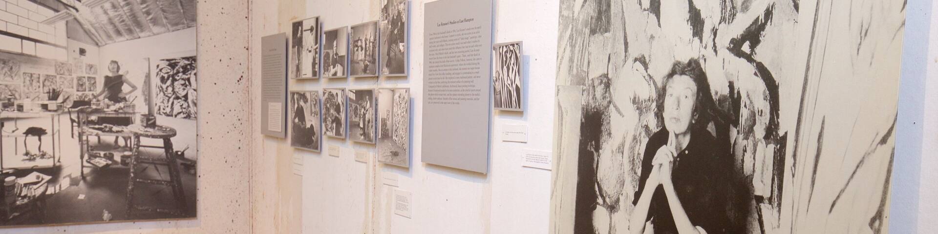 An art gallery with various black and white photographs and paintings on display.