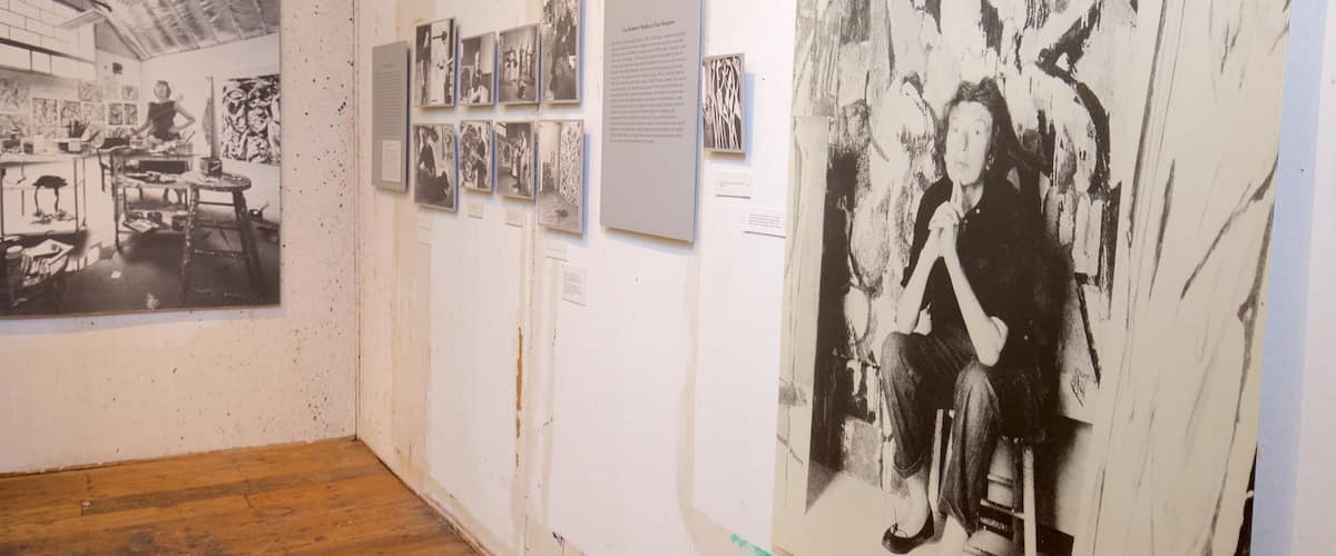 An art gallery with various black and white photographs and paintings on display.