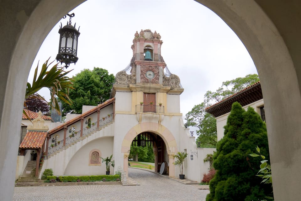 A historic building with a clock tower, arched entrance, and a cobblestone pathway.