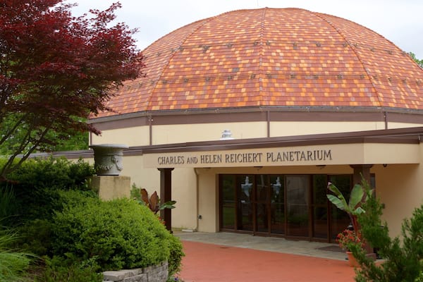 A building with a dome roof and a sign reading "Charles and Helen Reichert Planetarium".