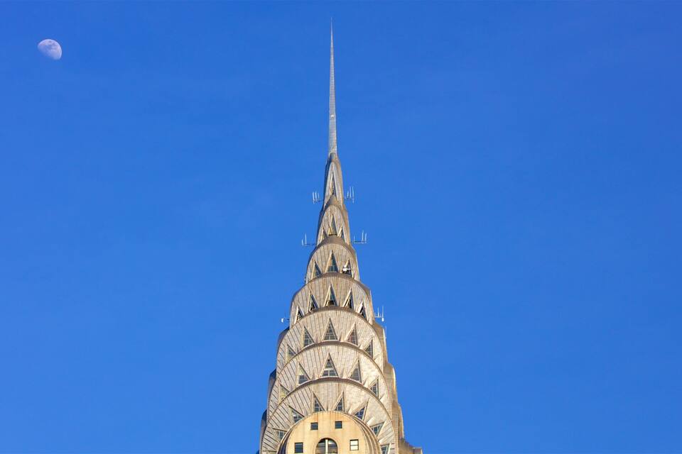 Der Turmknopf des Chrysler Buildings vor blauem Himmel.
