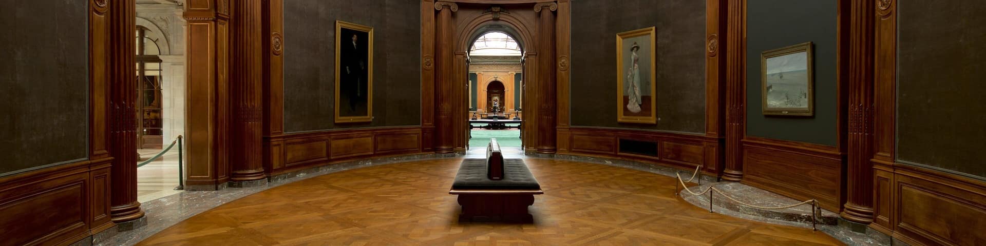 A grand hall with a high arched ceiling, wooden paneling, and a central table.