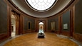 A grand hall with a high arched ceiling, wooden paneling, and a central table.