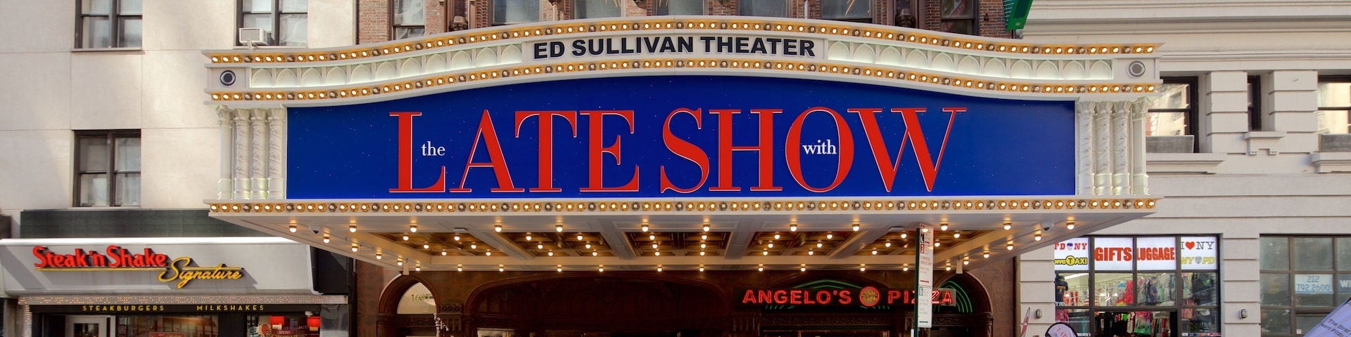 Ed Sullivan Theater que inclui uma cidade e sinalização assim como um grande grupo de pessoas