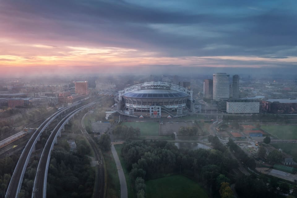 A stadium surrounded by urban buildings and highways.