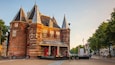 Un bâtiment historique doté de plusieurs tours et abritant un café appelé « Restaurant Café De ».