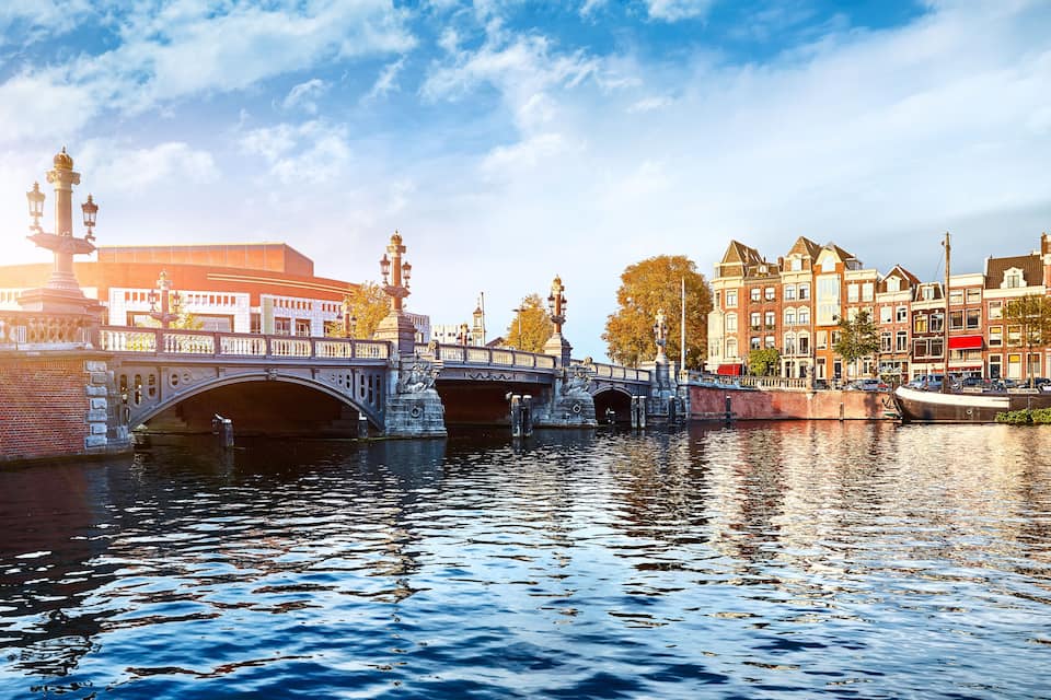 A historic bridge over a river, surrounded by traditional buildings and a modern structure.