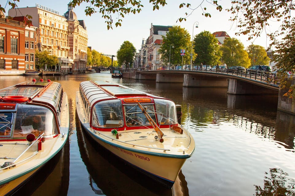 Un canal amb barques, un pont i edificis.