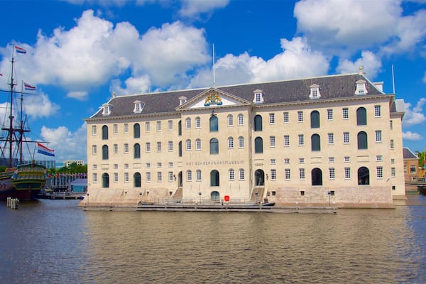 Ein historisches Gebäude mit zahlreichen Fenstern und einer Flagge auf dem Dach, gelegen am Wasser.