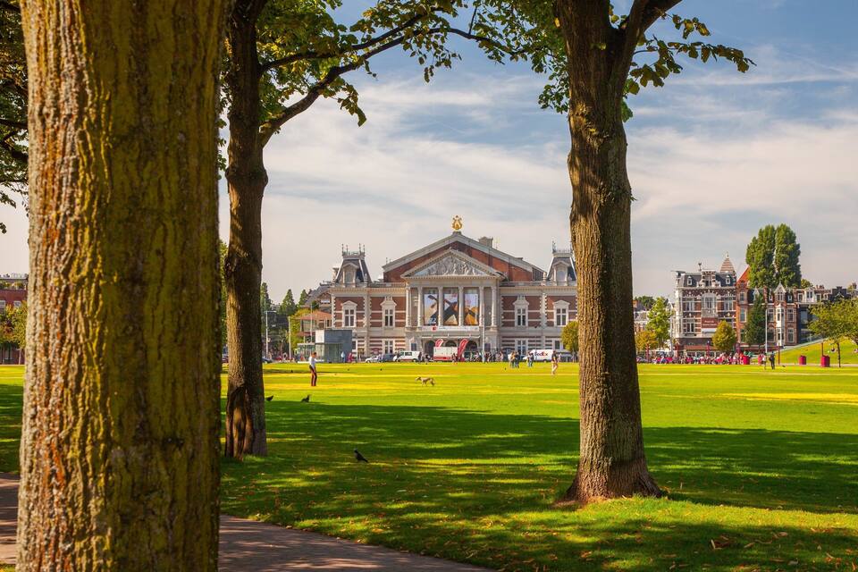 A large open park with a prominent building in the background.