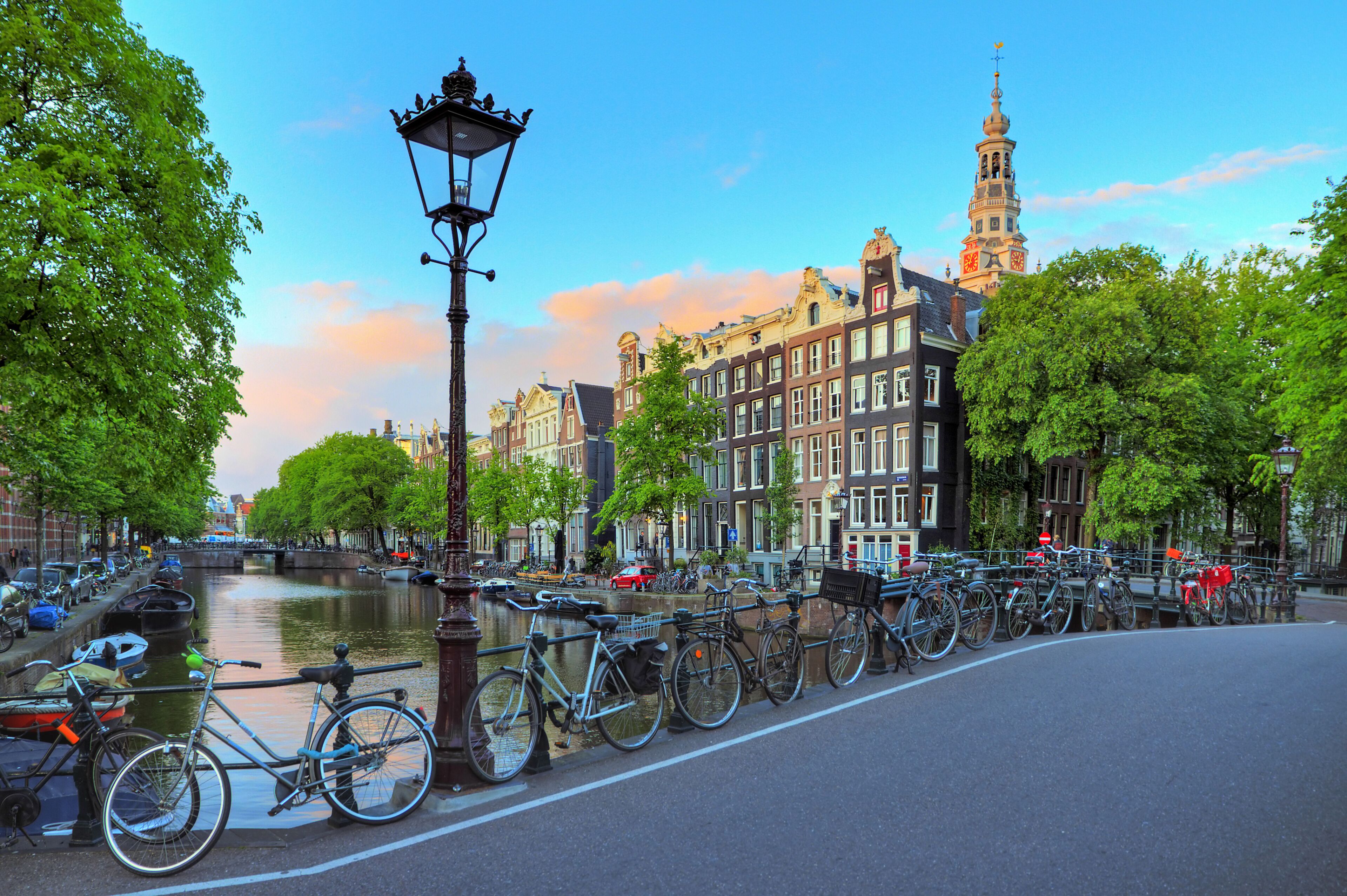 Amsterdam cityscape at sunset with a street lantern at the famous Kloveniersburgwal canal and the Southern Church in the Netherlands