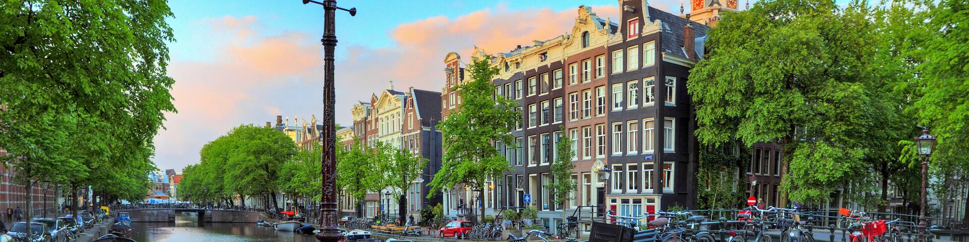 A canal with boats, bicycles, and historic buildings along the water's edge.