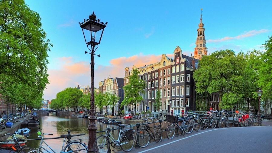 Amsterdam cityscape at sunset with a street lantern at the famous Kloveniersburgwal canal and the Southern Church in the Netherlands