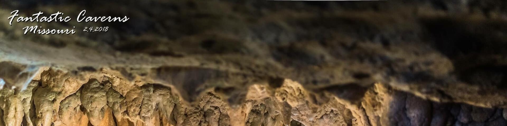 A cave with stalactites hanging from the ceiling.