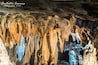 Eine Höhle mit von der Decke hängenden Stalaktiten.