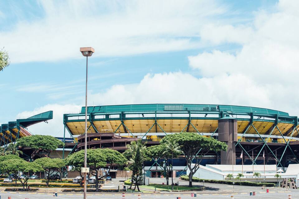 Un estadio grande con techo verde y zonas de asientos amarillas.