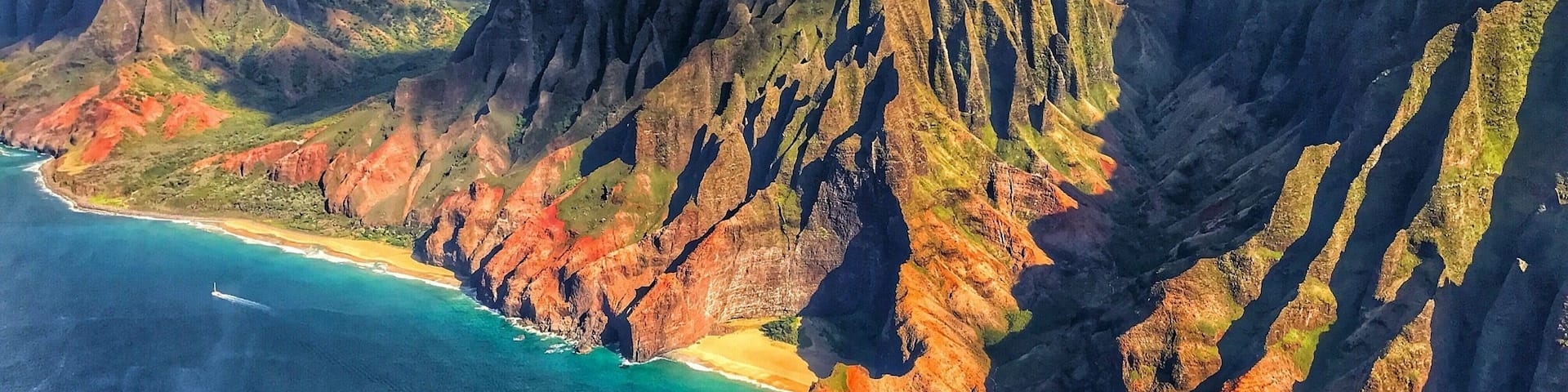 A coastal mountain range with steep cliffs and a beach.