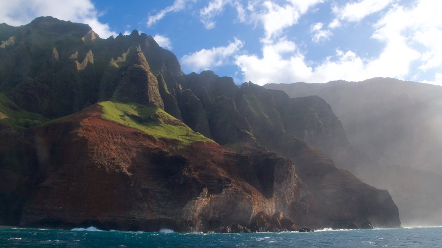 A rugged coastline with steep cliffs and a clear blue sky.