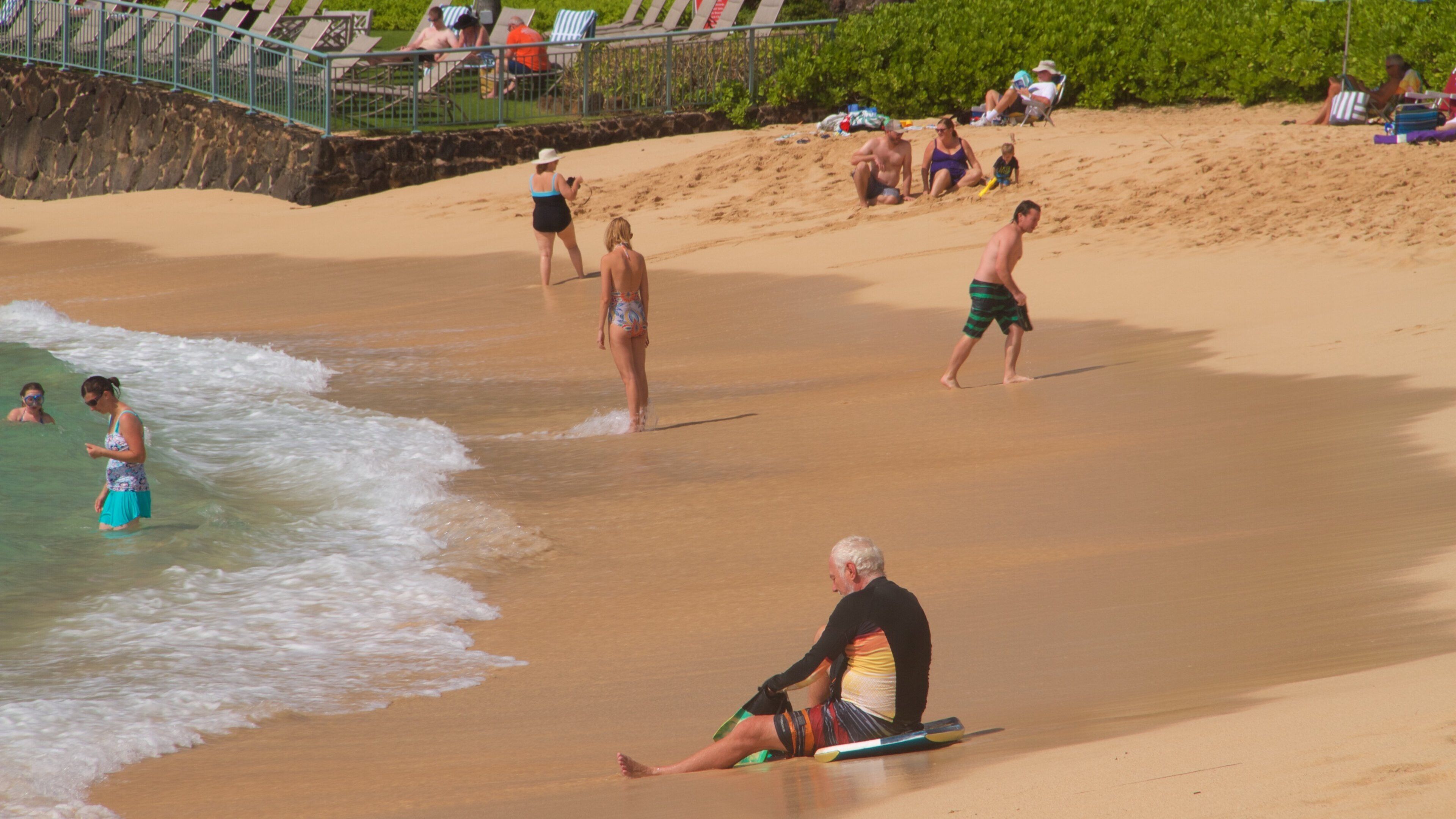 Poipu Beach showing a beach as well as a small group of people