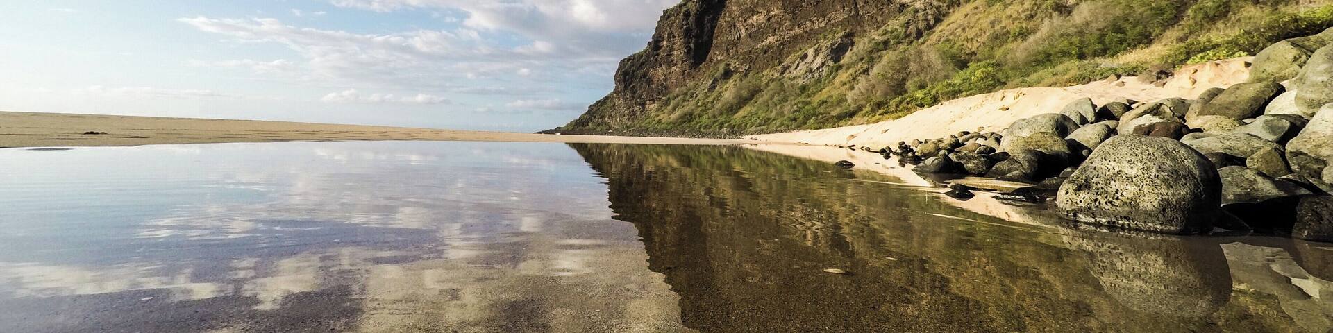 End of the road at the peaceful Polihale Beach and State Park ~ AKA ~ The longest sandy beach in all of the Hawaiian Islands. This is also the start of the remarkable Na Pali Coastline on the garden isle of Kauai. Four-wheel drive is recommended for the road leading to Polihale State Park. Rental car companies do not take emergency roadside service calls at this spot. If you still decide to go in with a two-wheel drive vehicle, be sure to stop at the local grocery store in Waimea town on your way to pick up a 12-pack of "Hawaiian Insurance"-- just in case you need to ask a local to pull you out of the sand ;)
#LifeAtExpedia #ExpediaLocalExpert #NaPaliCoast #Kauai #HawaiianIslands
