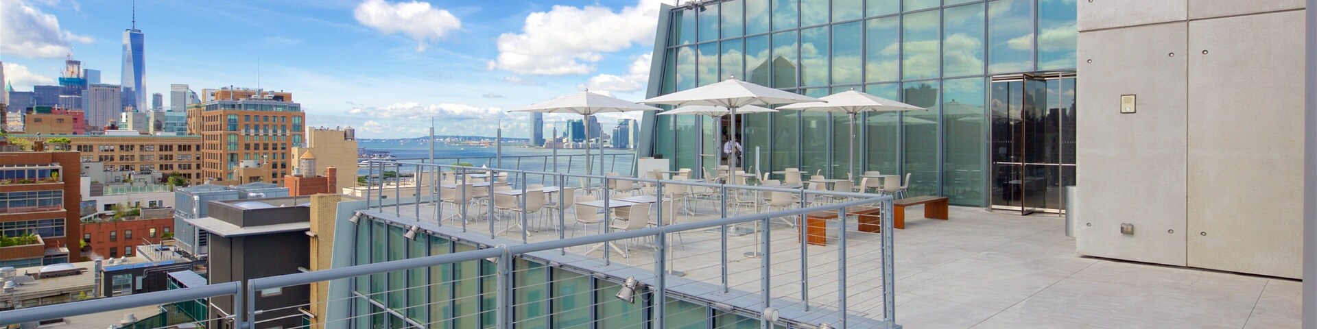 Terraço no telhado com área de estar ao ar livre, vista para um horizonte urbano e um corpo de água.