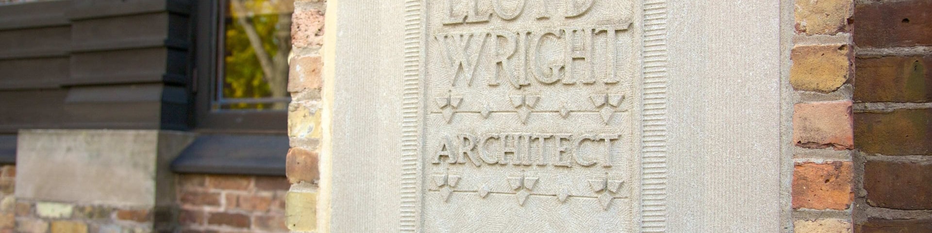 Una placa de piedra con el nombre 'FRANK LLOYD WRIGHT ARCHITECT' grabado.