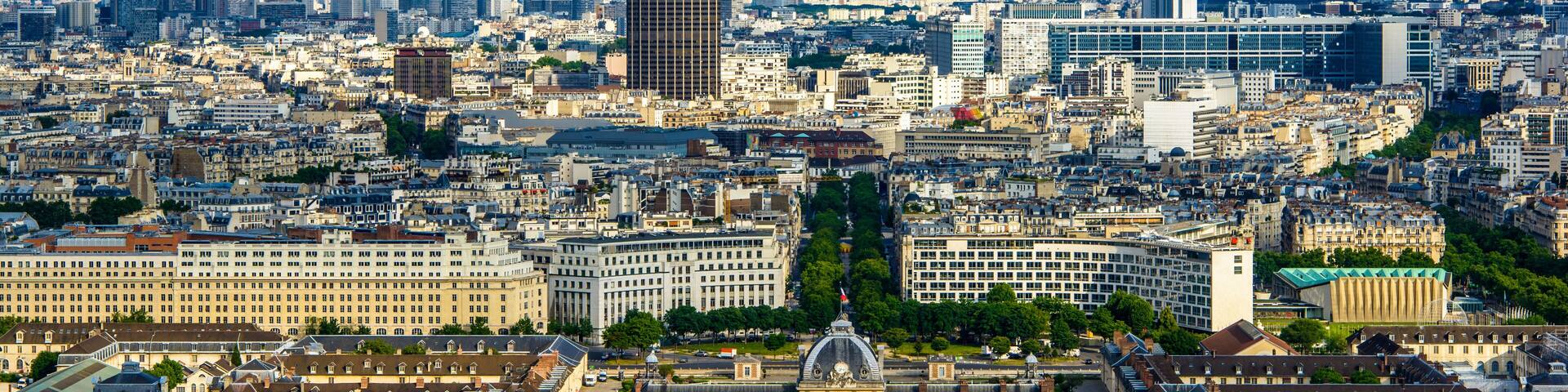 Un paisaje urbano con un moderno rascacielos destacado, edificios históricos y un río.