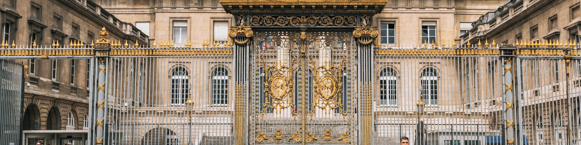 Un palacio imponente con puertas doradas ornamentadas y arquitectura clásica.