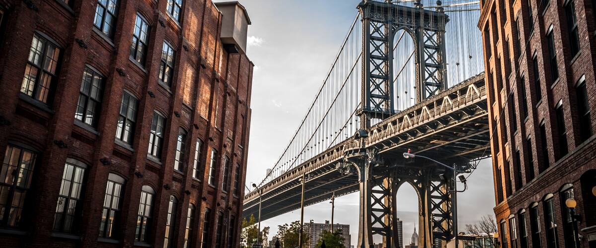 Manhattan bridge seen from a narrow alley enclosed by two brick buildings on a sunny day in summer, Shutterstock ID 317400725, Purchase Order: -