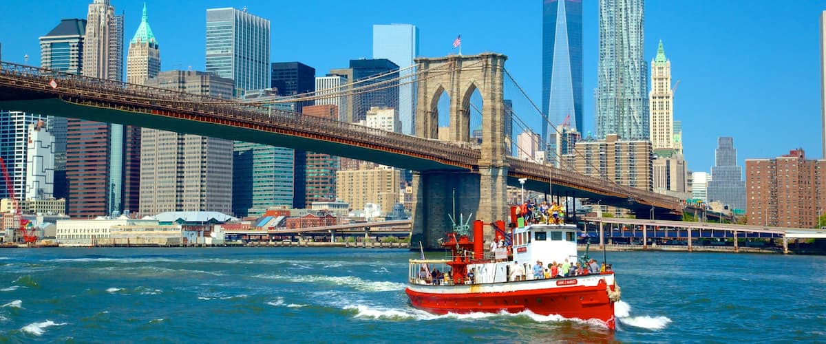 Brooklyn Bridge featuring a ferry, a river or creek and a bridge