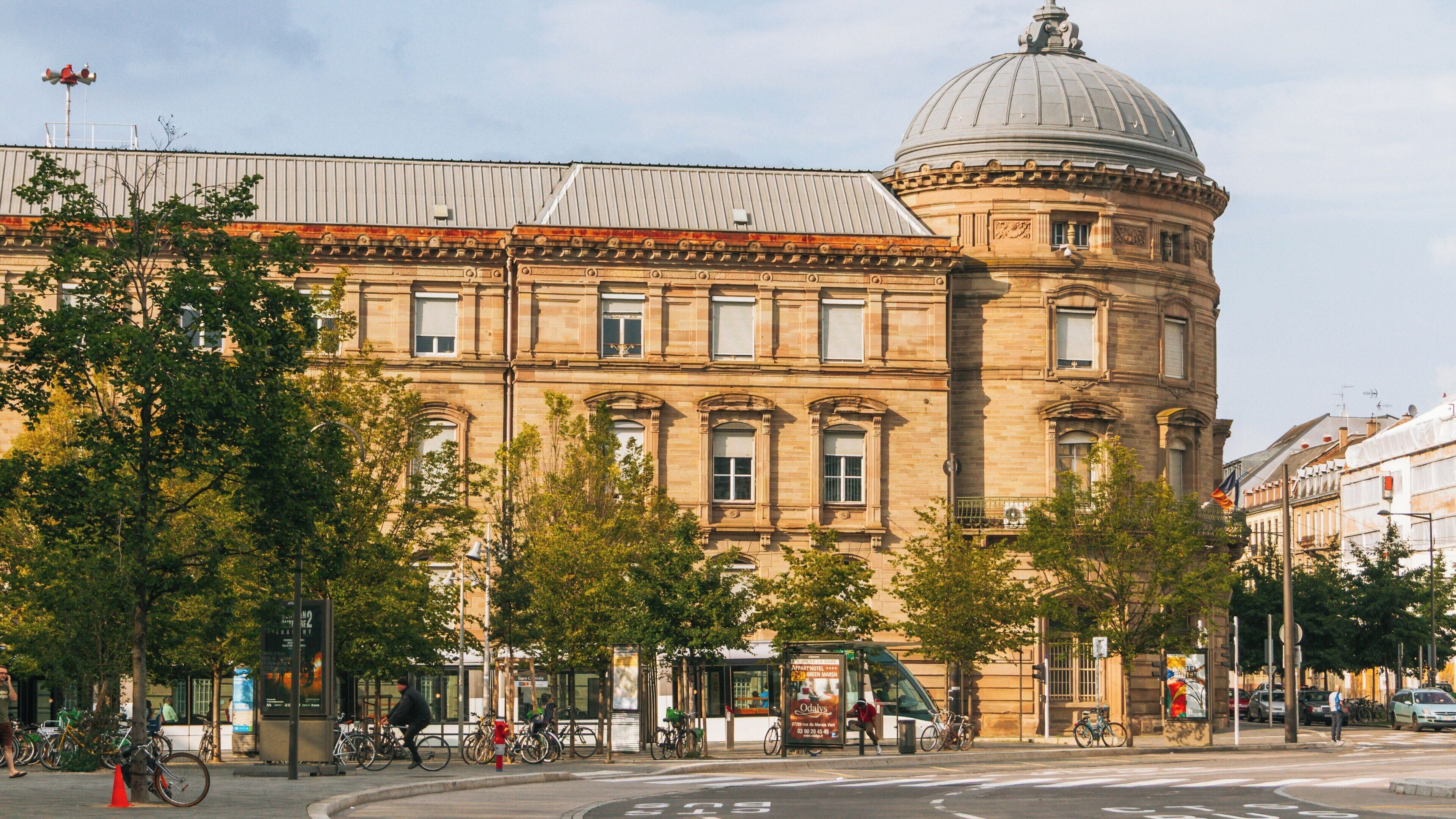 Historic architecture and vibrant atmosphere at Train Station Square in Quartier de la Gare, Strasbourg, France during a sunny day
