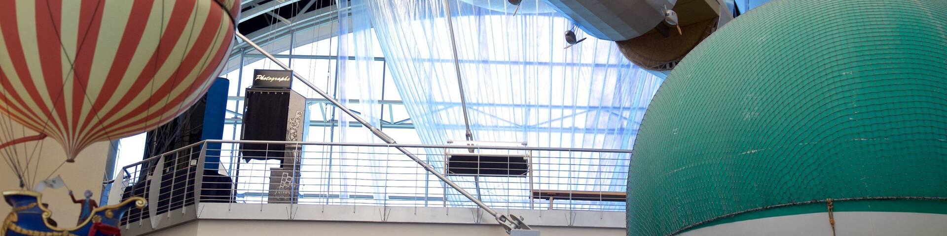 A large indoor exhibition with a zeppelin and hot air balloons.