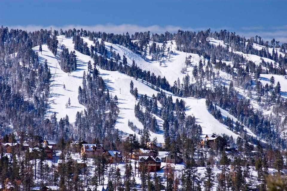 A snow-covered mountain with ski slopes and cabins.