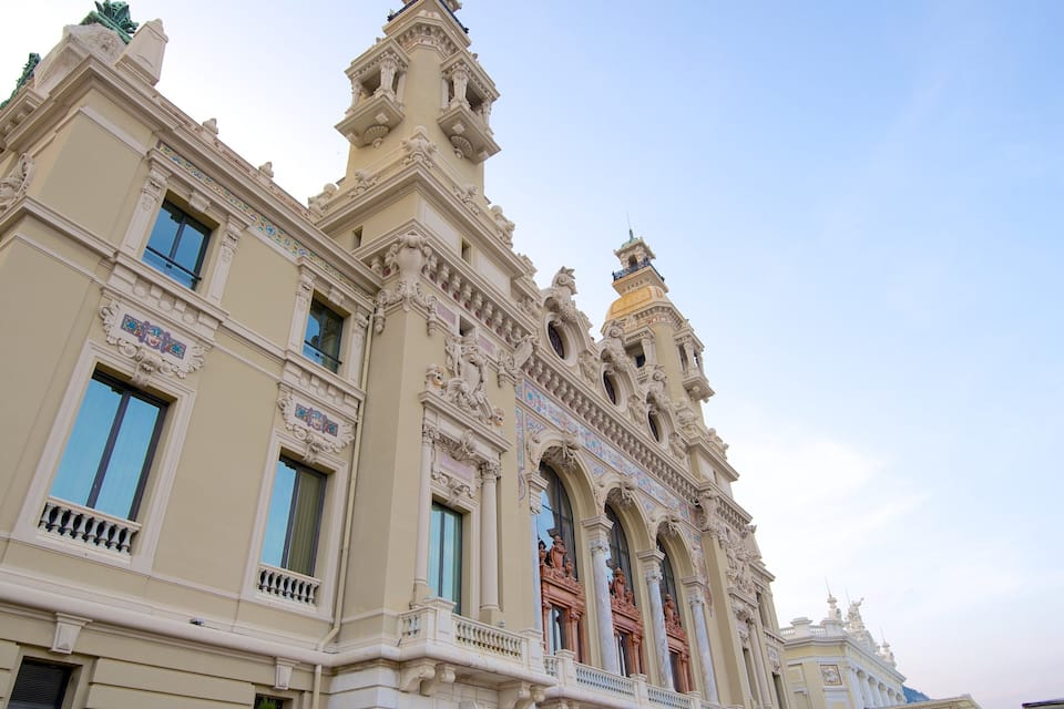 Un edificio imponente y ricamente decorado, con detalles arquitectónicos intrincados, incluyendo estatuas y molduras ornamentales.