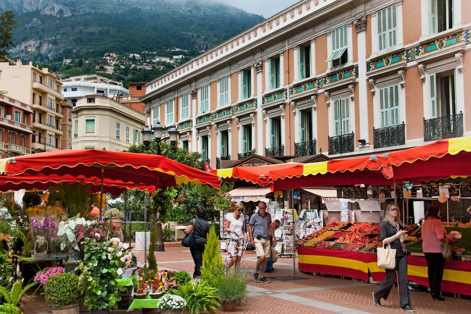 A bustling outdoor market with colorful stalls and a variety of plants and flowers.