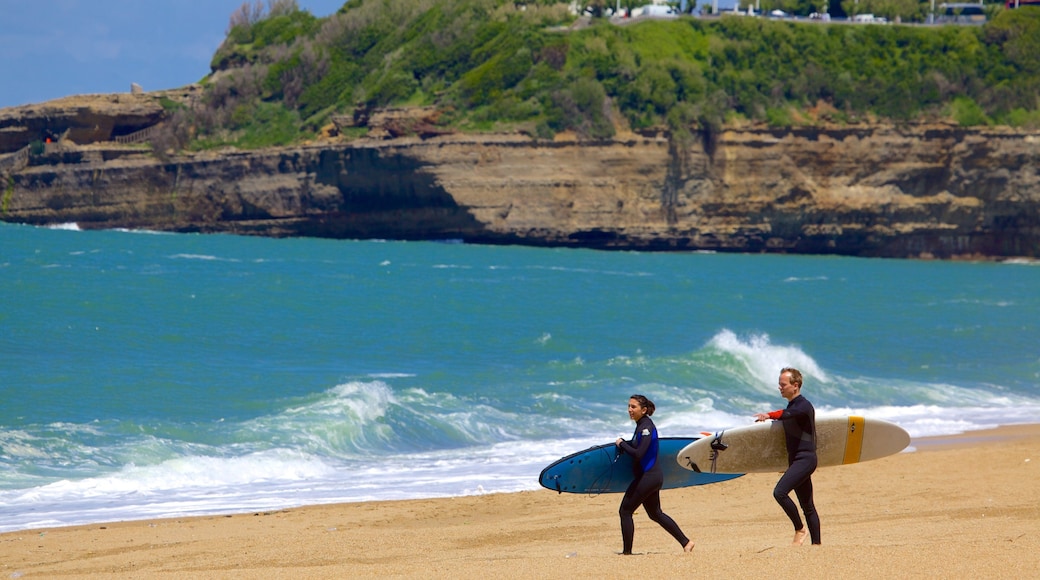 Grand Beach featuring rocky coastline, surfing and a sandy beach