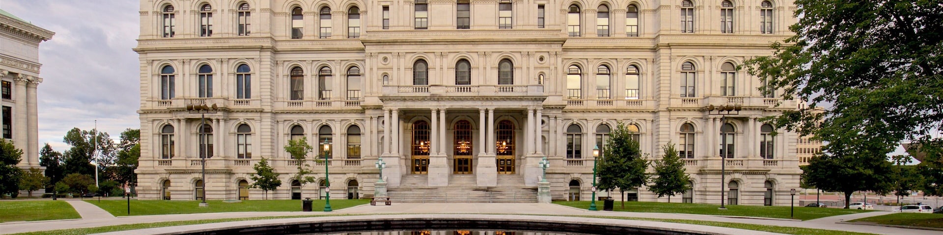 New York State Capitol Building featuring a pond and heritage architecture