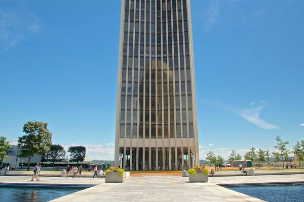 Corning Tower featuring a pond and a skyscraper
