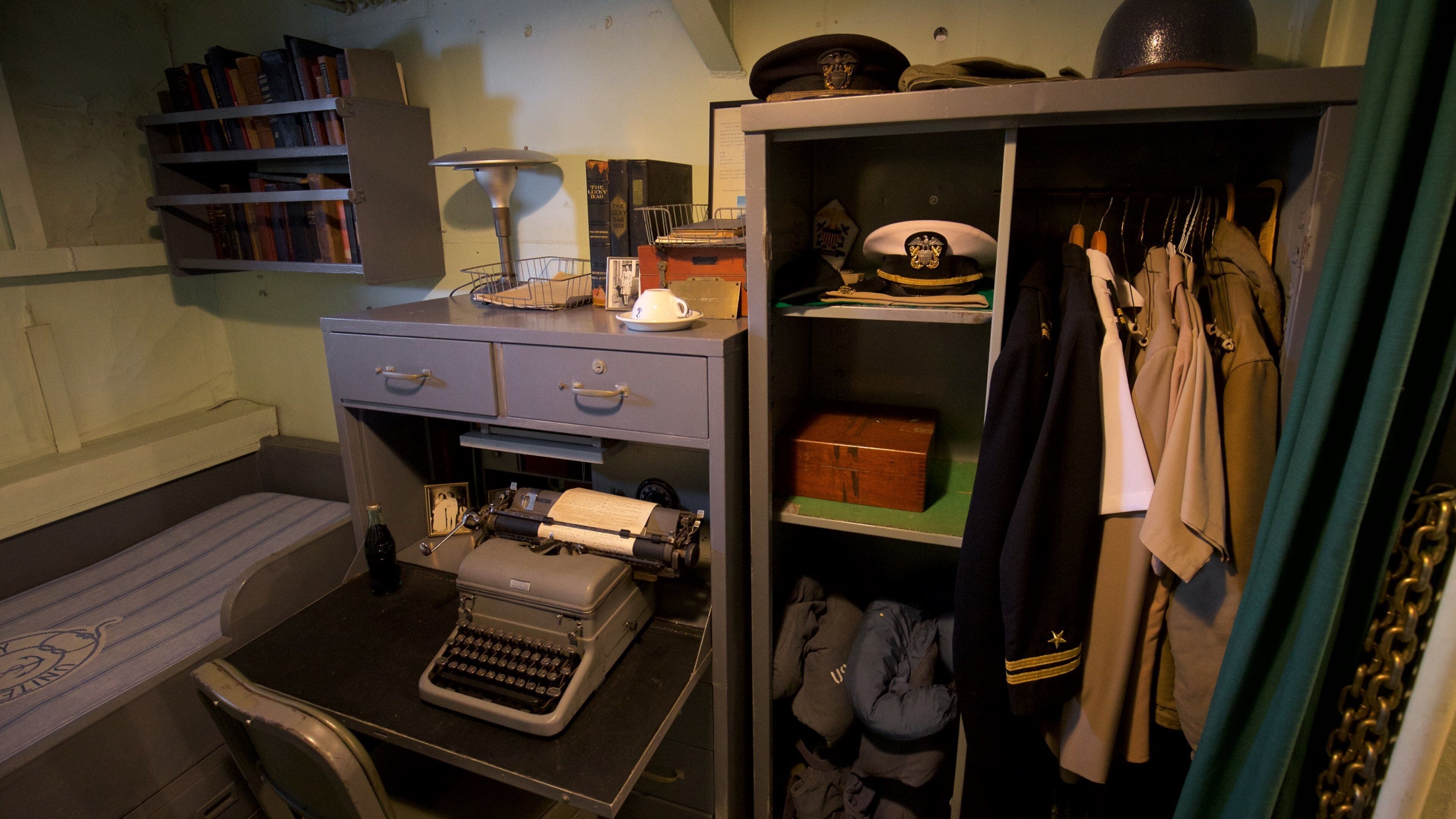 Een klassiek kantoor met een typmachine, boekenkasten en een kapstok met hoeden.