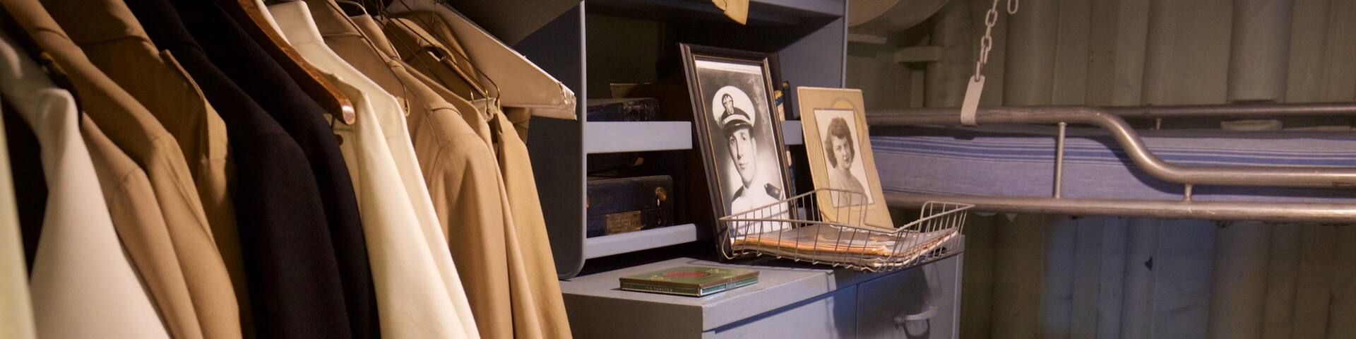 A storage area with clothes, a framed photo, and a newspaper.