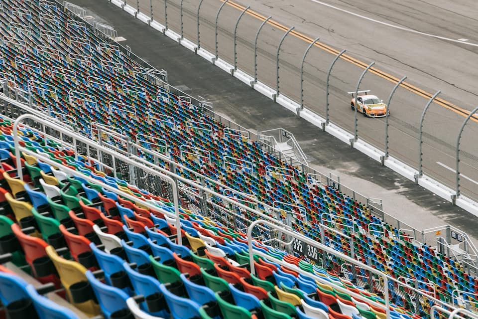Una pista de carreras con asientos de colores y un coche en la pista.