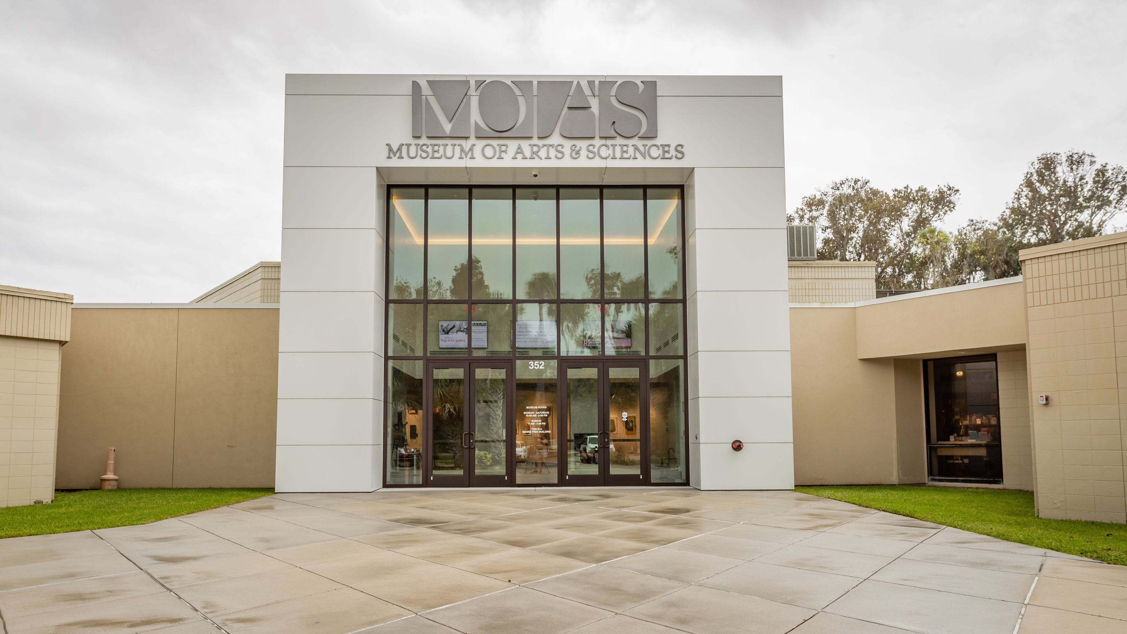 The exterior of the NOVAIS Museum of Arts & Sciences, featuring a modern facade with large glass windows and a tiled entrance area.