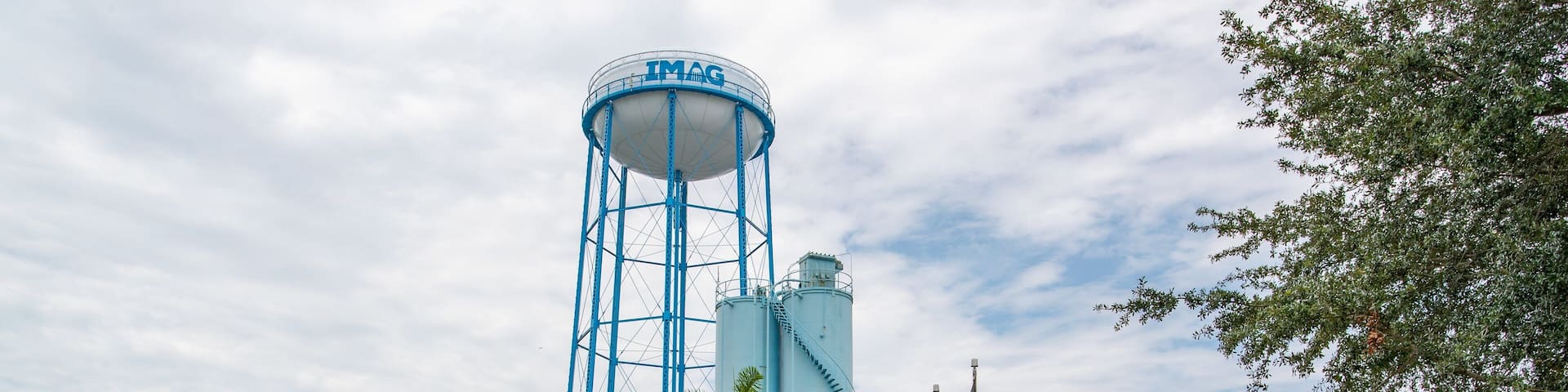 A water tower, a building labeled IMAG History & Science Center, palm trees, and a parking lot.