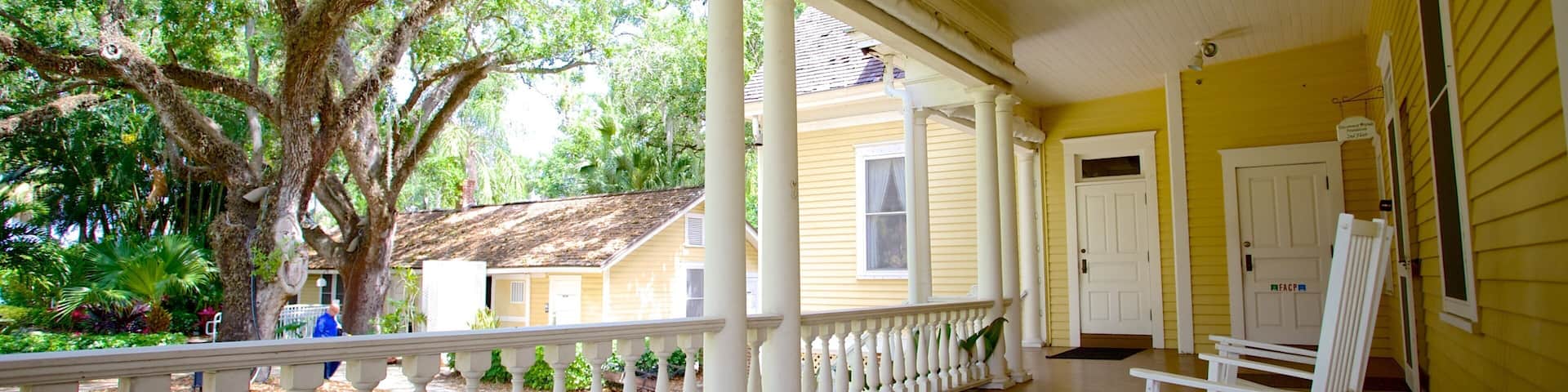 A porch with white railings and a rocking chair.