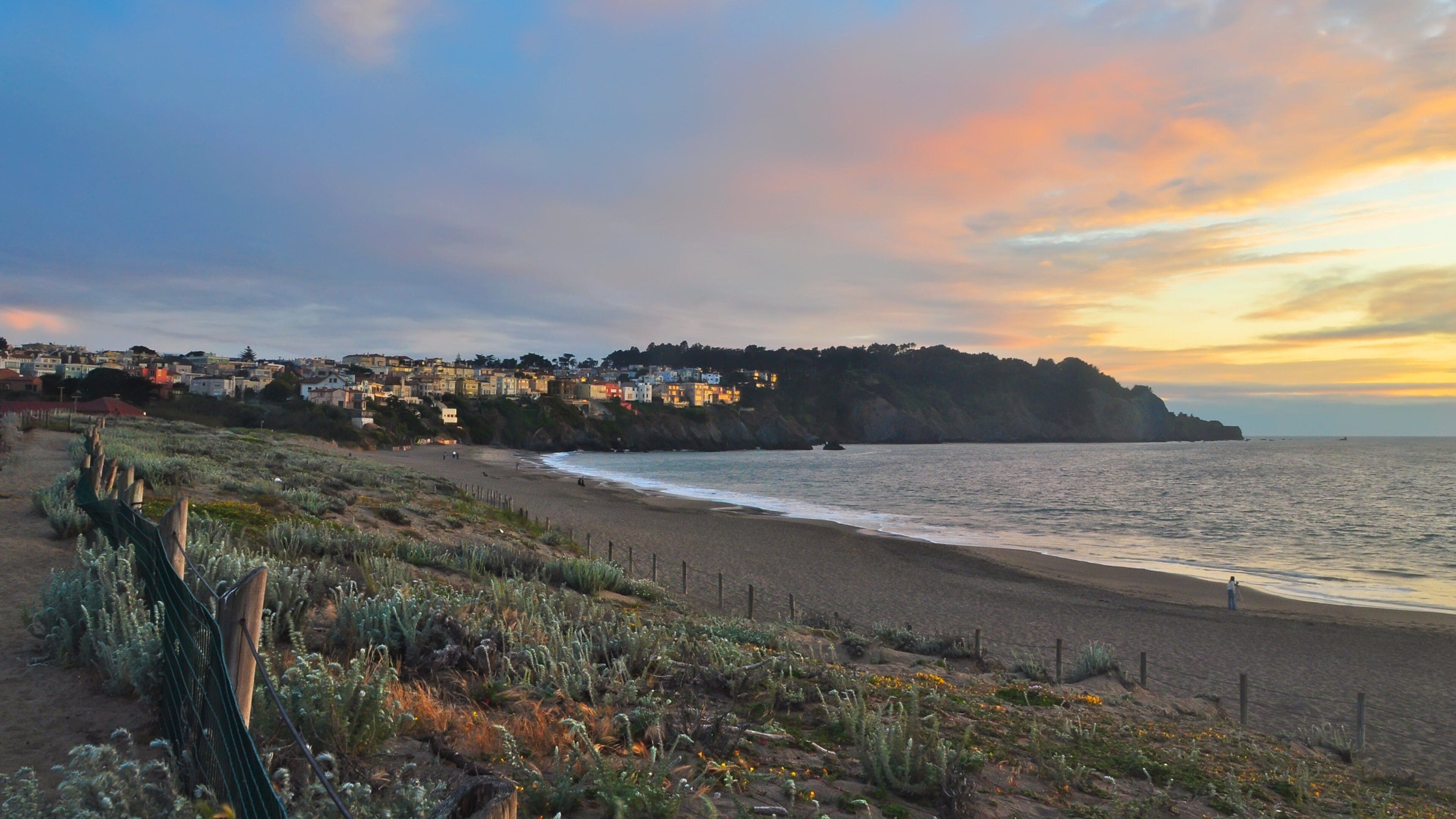 Beautiful sunset view over Baker Beach with coastal cliffs and tranquil waves in San Francisco, California