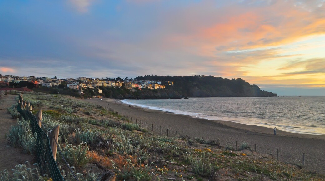 Beautiful sunset view over Baker Beach with coastal cliffs and tranquil waves in San Francisco, California