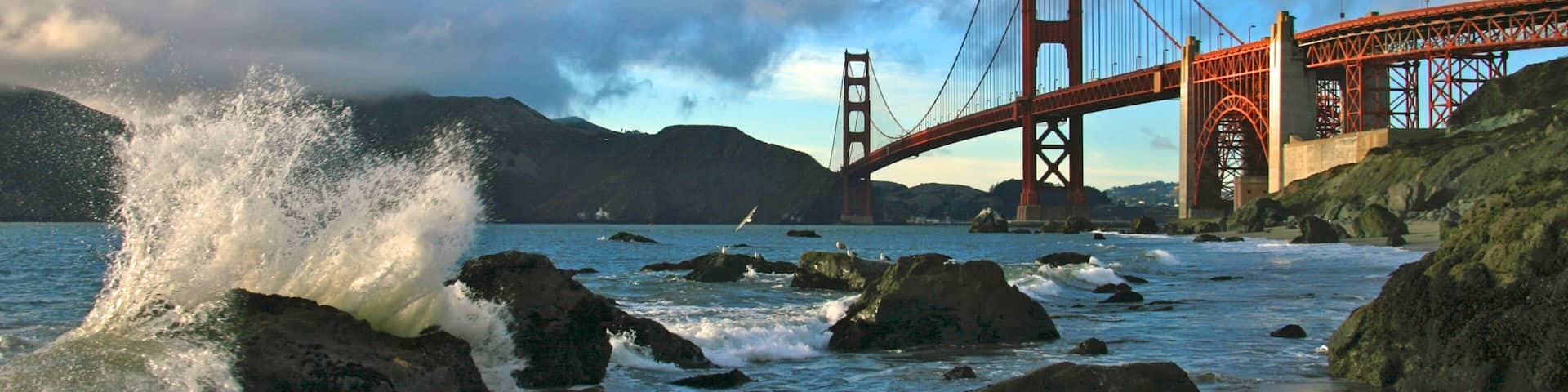 Baker Beach offering stunning views of Golden Gate Bridge and crashing waves along the shoreline in San Francisco